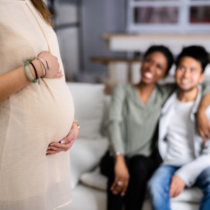 Couple and pregnant woman share a heartfelt moment